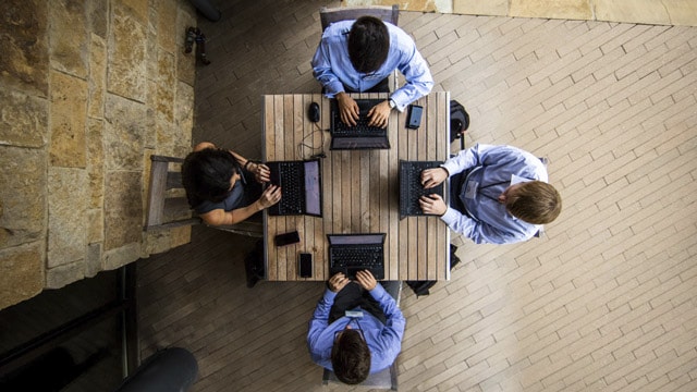 Professionals working on their laptops in breakout area of office